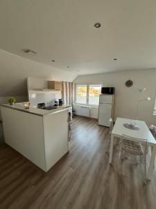 een keuken en een woonkamer met een tafel en een keuken en een tafel en stoelen bij Appartement tout confort 60 m² in Haveluy