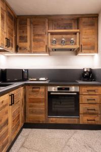 a kitchen with wooden cabinets and a black oven at Maroc Mountain Chalet in Madonna di Campiglio