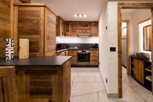 a kitchen with wooden cabinets and a black counter top at Maroc Mountain Chalet in Madonna di Campiglio