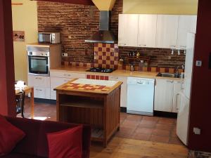 a kitchen with white cabinets and a table in it at Can Penjarella II in Arbúcies