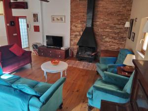 a living room with blue couches and a fireplace at Can Penjarella II in Arbúcies