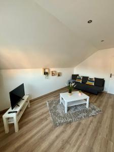 een woonkamer met een bank en een tafel bij Appartement tout confort 60 m² in Haveluy