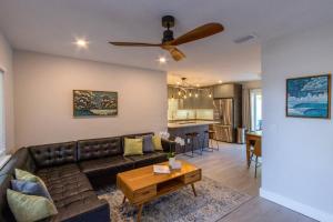 a living room with a couch and a ceiling fan at NEW! Stylish & Cozy Sea Grape near Beach & Flagler in New Smyrna Beach