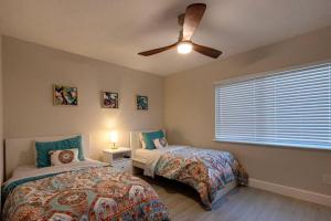 a bedroom with two beds and a ceiling fan at NEW! Stylish & Cozy Sea Grape near Beach & Flagler in New Smyrna Beach
