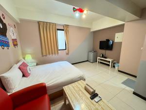 a room with a bed and a couch and a tv at Yi Chung Disney in Taichung