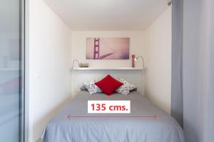 Un dormitorio con una cama con un cartel que diga: en Living Las Canteras Homes - WORKOUT & FREE BIKES, en Las Palmas de Gran Canaria