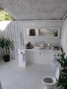 Baño blanco con lavabo y aseo en Tropical Glamping Nusa Penida - Private Romantic Seaside Bungalow Diamond Beach, en Nusa Penida