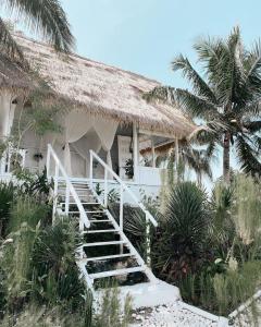 a staircase leading to a house with palm trees at Tropical Glamping Nusa Penida - Private Romantic Seaside Bungalow Diamond Beach in Nusa Penida