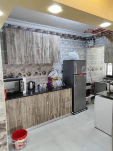 a kitchen with wooden cabinets and a refrigerator at Gardenia compound in Cairo