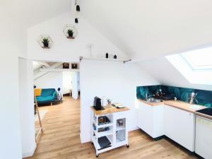 a kitchen with white cabinets and a window at Appart de charme aux pieds des remparts, terrasse in Guérande