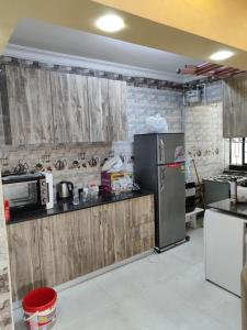 a kitchen with wooden cabinets and a refrigerator at Gardenia compound in Cairo