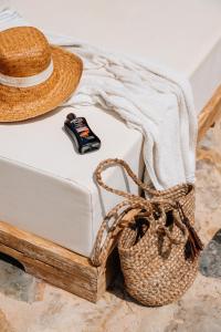 um chapéu de palha sentado numa cama ao lado de um cesto em Cuatre Finques em Jalón
