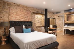 a bedroom with a bed and a brick wall at SUITE 1907 AVILES in Avilés