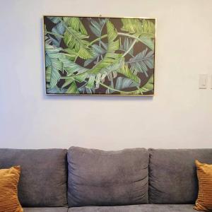 マニラにあるQE811 Cozy 1 BR & Sofa Bed Free WiFi & Pool Accessのソファの上に掛けられた絵画 +11枚の写真