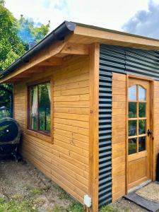 Cabaña de madera con puerta y ventana en Siempre Verde, en Puerto Tranquilo