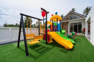 a playground with a slide on the grass at บ้านลินลดา พูลวิลล่าขนอม in Ban Phang Phrao