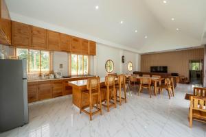 a kitchen and dining room with a table and chairs at บ้านลินลดา พูลวิลล่าขนอม in Ban Phang Phrao