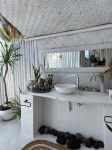 Baño blanco con lavabo y espejo en Tropical Glamping Nusa Penida - Private Romantic Seaside Bungalow Diamond Beach, en Nusa Penida