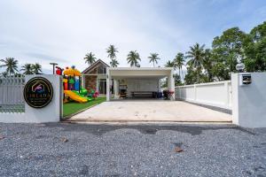 a backyard with a white fence and a playground at บ้านลินลดา พูลวิลล่าขนอม in Ban Phang Phrao