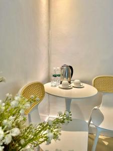 a white table with chairs and a tea kettle on it at Hotel Euroasia By BLUEBOOKERS in Angeles