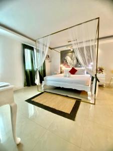 a bedroom with a large white bed with curtains at Hotel Euroasia By BLUEBOOKERS in Angeles