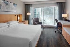 um quarto de hotel com uma cama grande e uma secretária em Delta Hotels by Marriott Toronto em Toronto