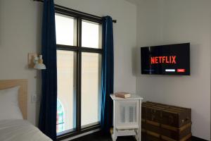 Schlafzimmer mit einem Bett und einem Fenster mit einem TV in der Unterkunft Le Saint-Crème in Alma