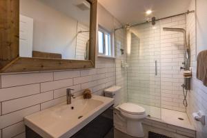 a bathroom with a sink and a toilet and a mirror at NEW Stylish & Cozy Dune Daisy near Beach & Flagler in New Smyrna Beach