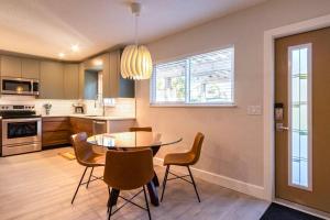 a kitchen and dining room with a table and chairs at NEW Stylish & Cozy Dune Daisy near Beach & Flagler in New Smyrna Beach