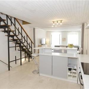 a white kitchen with a staircase in a house at City center house in Vodice