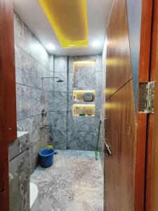 y baño con lavabo y ducha. en Luxury Family Suite Homestay in Vrindavan with Lobby, Balcony, Kitchen, Washing Machine - Free Wifi, No Parking, en Vrindāvan
