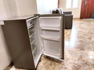 范兰德凡Premium Homestay Near Banke Bihari Ji with Power Backup - Free WiFi - Washing Machine etc的空冰箱,门打开在房间里