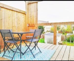 a patio with a table and chairs on a deck at Appart de charme aux pieds des remparts, terrasse in Guérande