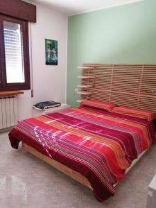 um quarto com uma cama grande e uma cabeceira em madeira em Casa Dolce Casa - Appartamento a Porto Viro em Porto Viro