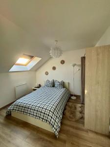 een slaapkamer met een bed met een geruite deken bij Appartement tout confort 60 m² in Haveluy