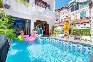 a pool in the middle of a house with pink inflatables at Villa Hồ Bơi HOÀNG ĐỨC Trung Tâm BÃI SAU in Vung Tau