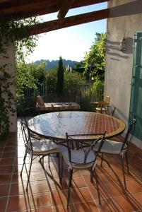 einen Glastisch und Stühle auf einer Terrasse in der Unterkunft Les Dentelles in Beaumes-de-Venise