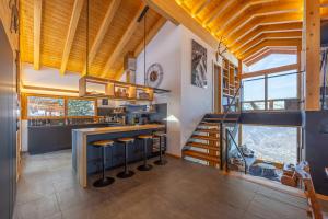 a kitchen with wooden ceilings and a staircase in a house at Ciel Etoilé - Magnifique Chalet, 14 personnes - vue incroyable in Nendaz