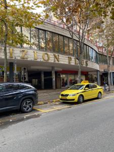 a yellow car parked in front of a building at Maison D'artiste Boutique Hostel in Tirana