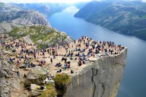 una multitud de personas de pie en el borde de una montaña en The Green Door H3, en Stavanger