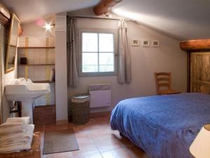 ein Schlafzimmer mit einem Bett, einem Waschbecken und einem Fenster in der Unterkunft Les Dentelles in Beaumes-de-Venise