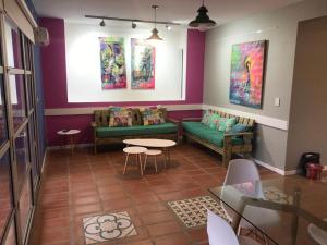 a living room with a couch and tables and paintings at Apart Gallery - San Lorenzo - Salta in Salta