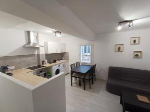 亞維儂的住宿－T3 cosy climatisé, intra-muros Avignon，厨房以及带桌子和沙发的客厅。
