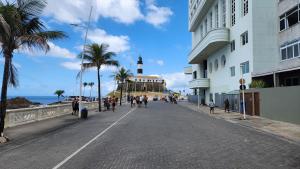 una calle frente a un edificio con una torre de reloj en Barra Stella do Mar Studio, en Salvador