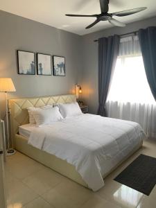 1 dormitorio con 1 cama blanca y ventilador de techo en DNAURA HOMESTAY BATU BURUK TERENGGANU, en Kuala Terengganu