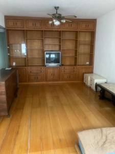 um quarto amplo com pisos em madeira e uma televisão de ecrã plano em Apartamento no Hotel Quitandinha 40 em Petrópolis