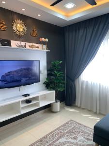 sala de estar con TV de pantalla plana grande en DNAURA HOMESTAY BATU BURUK TERENGGANU, en Kuala Terengganu
