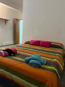 a large bed with colorful sheets and towels on it at Departamento AHNEN Barrio ALTA CORDOBA PLANTA ALTA a dos cuadras Plaza de Alta Cordoba in Córdoba