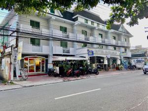 a white building with motorcycles parked in front of a street at Hotel Euroasia By BLUEBOOKERS in Angeles