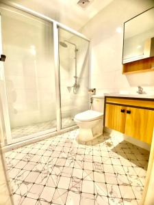 ein Bad mit einem WC und einer Glasdusche in der Unterkunft Hotel Euroasia By BLUEBOOKERS in Angeles